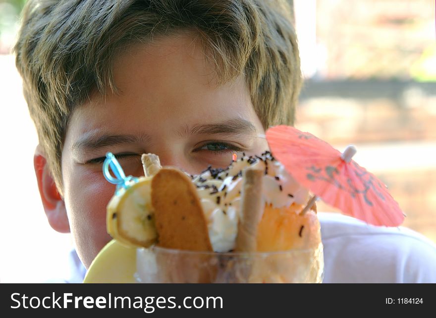 The teenager eats frozen in cafe. The teenager eats frozen in cafe