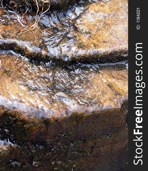 A rocky stream flowing down the side of a rock ledge. A rocky stream flowing down the side of a rock ledge.