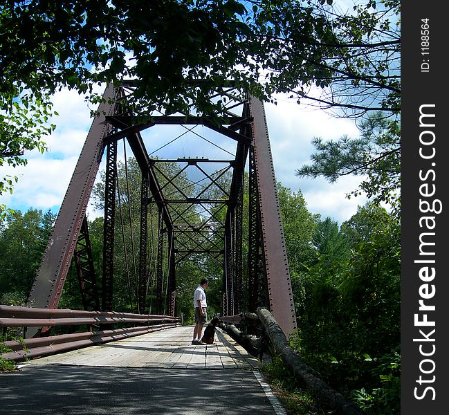 A Gentleman and his dog standing (and sitting) on a footbridge overlooking the Menominee River off Miscauno Island. . A Gentleman and his dog standing (and sitting) on a footbridge overlooking the Menominee River off Miscauno Island.