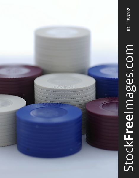 Closeup of stacked poker chips - red, white, and blue chips in seven (7) piles