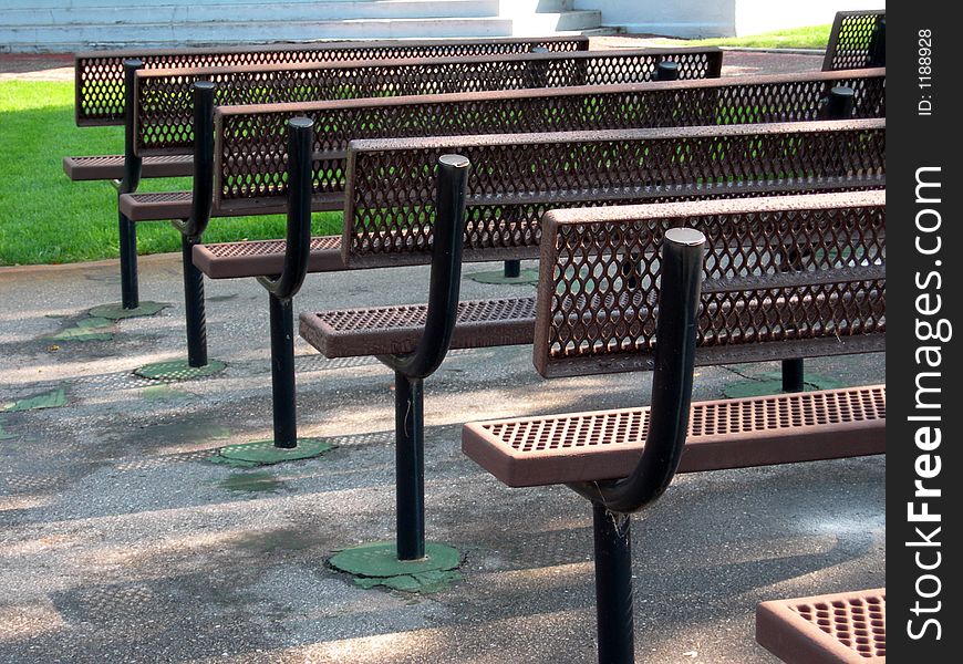 Row of metal benches in a city park. Row of metal benches in a city park.