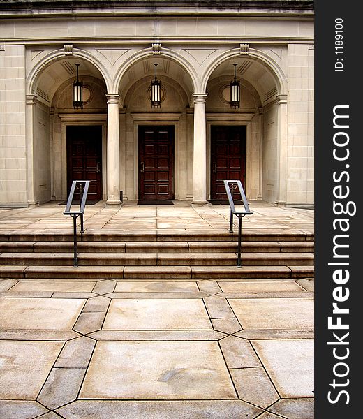 Arched doorways and stairs with lamps and railings.