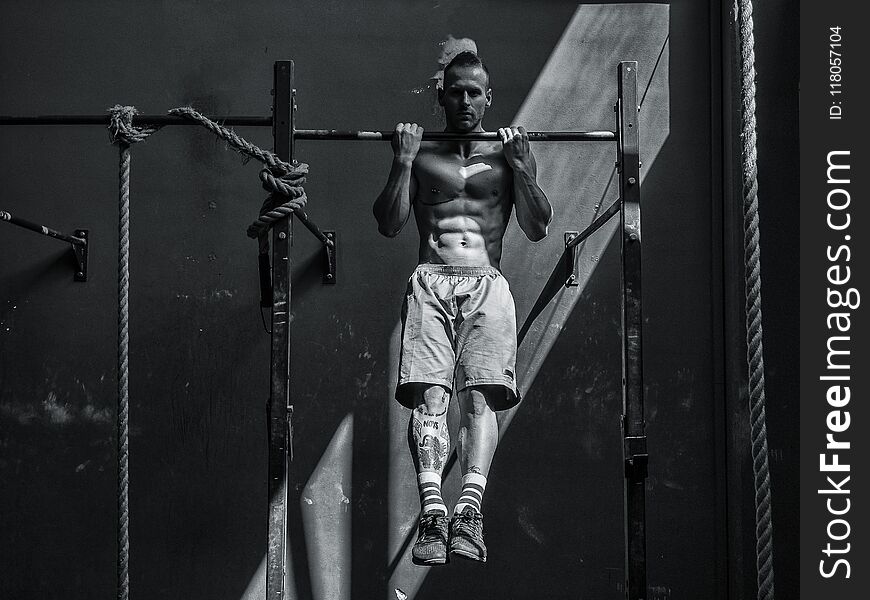 Young man hanging from gym equipment