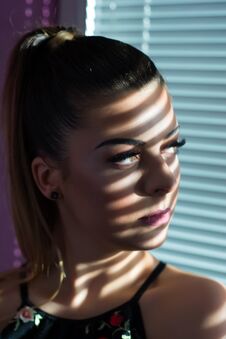 Serious Girl Face With Shadow Of Venetian Blinds Looking Through Window In Sunset At Home Stock Photo Serious Girl Face With Shadow Of Venetian Blinds Looking Through Window In Sunset At Home Stock Photo