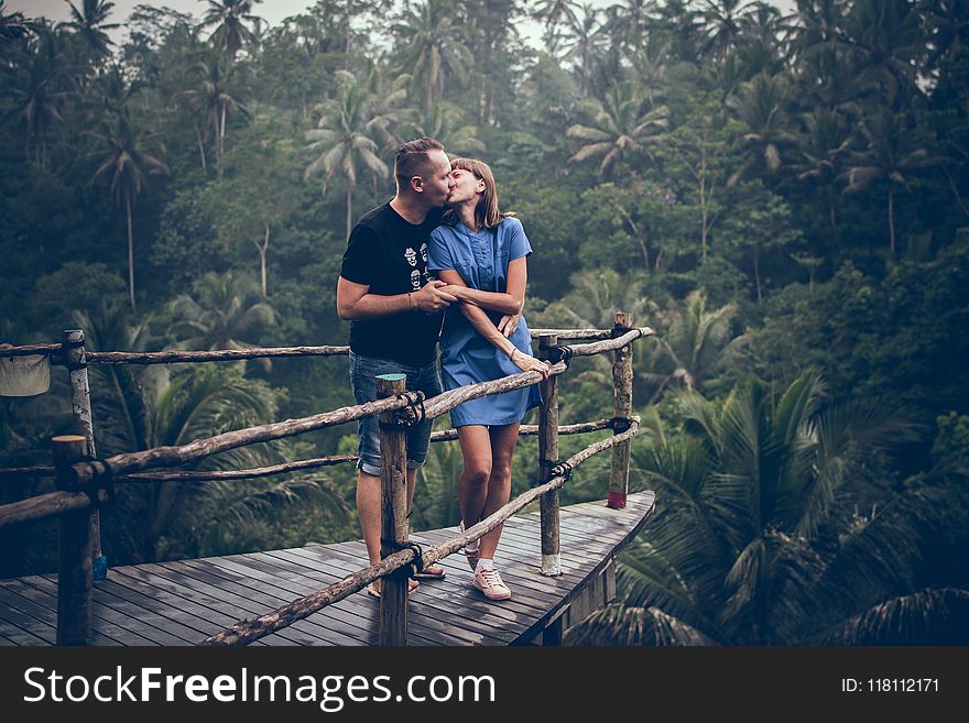Man Kissing Woman on Cliff