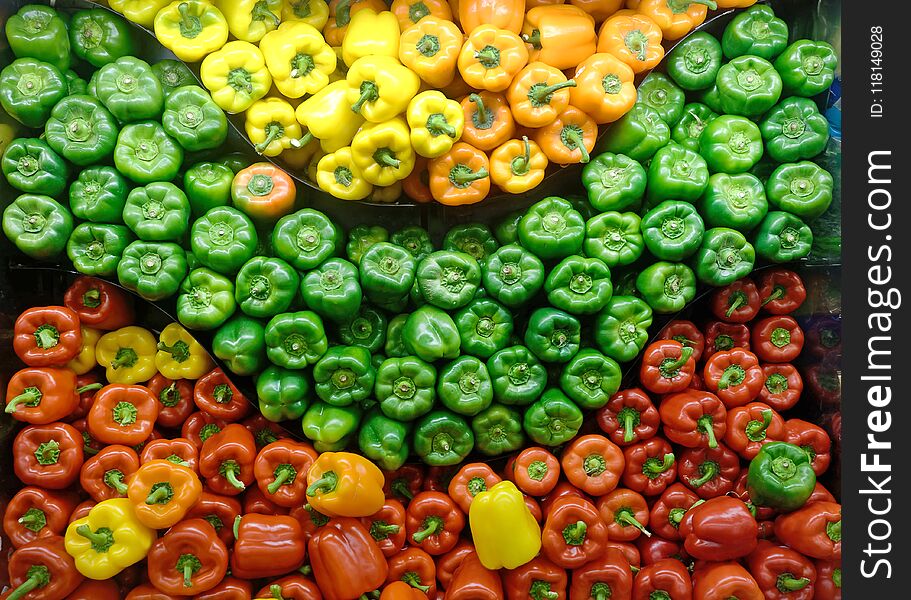 Yellow, orange, red, and green bell peppers produce display. Yellow, orange, red, and green bell peppers produce display.