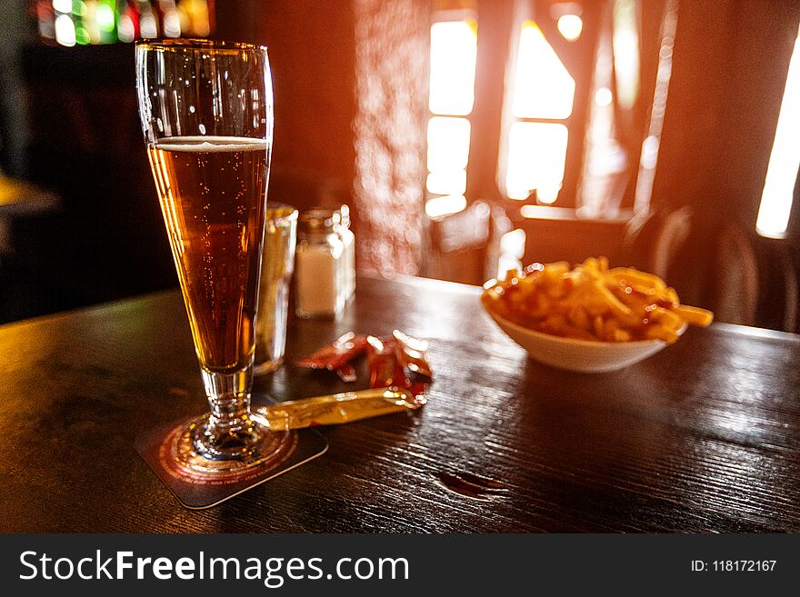 Cold Beer In A Glass On A Wooden Table In The Pub