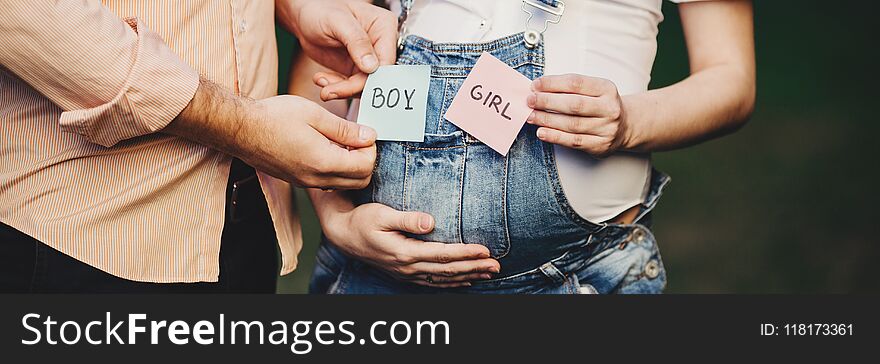 Baby gender. Mom and dad with BOY and GIRL cards