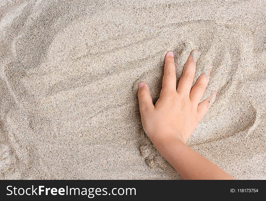 The child is playing with the sea sand. Relax, meditation