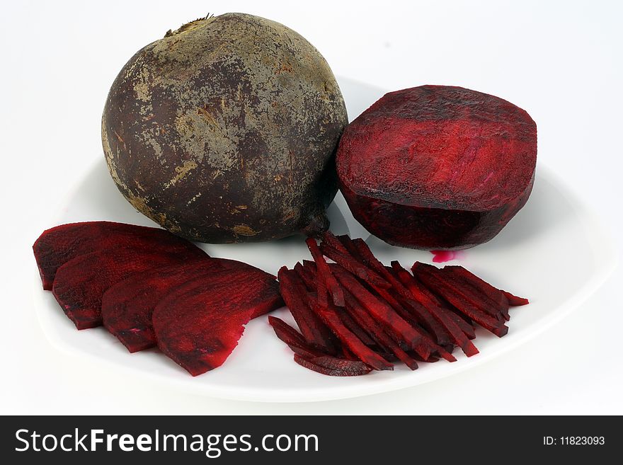 Ripe red beet is cut by segments and straws. On a plate traces of beet juice. A beet is prepared for to cook the Ukrainian borsch. Ripe red beet is cut by segments and straws. On a plate traces of beet juice. A beet is prepared for to cook the Ukrainian borsch.