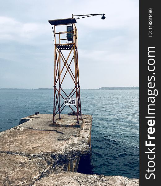 Watch Tower With Lamp Near Body Of Water