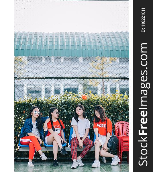 Four Girls Sitting In Gray Steel Bench