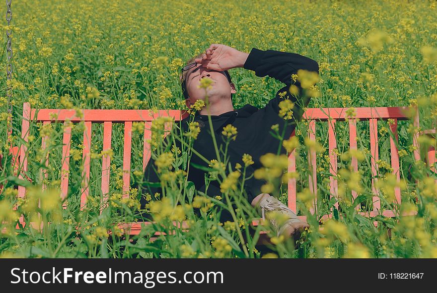 Man In Black Hoodie Sitting On Red Bench