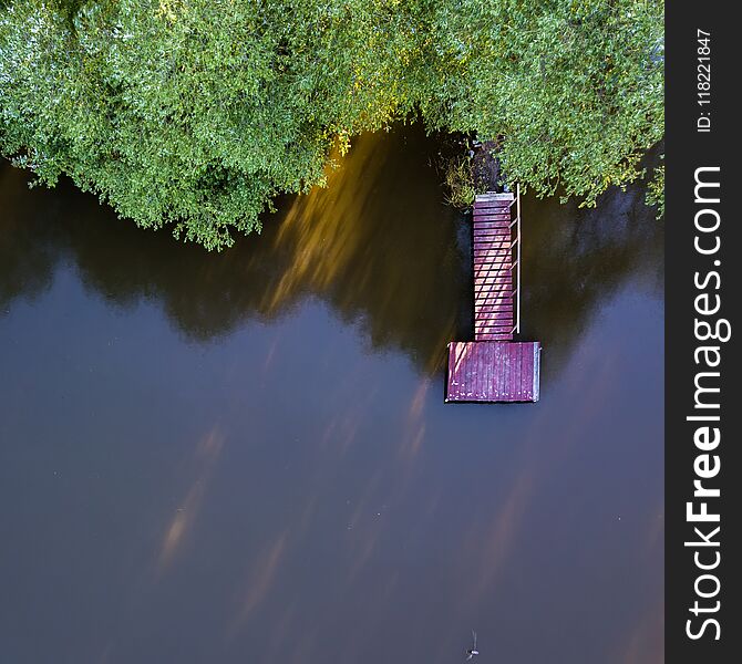 View From Above On A Wooden Bridge, Lake And Green Trees