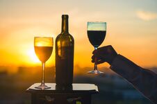 Silhouette Of Female Hand Toasting Wine On Sunset Background. Stock Photos