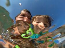 Underwater View Of A Father And Her Daughter With Distorted Face Stock Photo