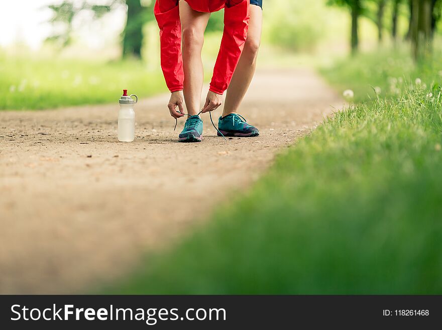 Woman runner tying sport shoes. Walking or running legs, autumn adventure and exercising outdoors. Motivation and inspiration fitness concept outside. Woman runner tying sport shoes. Walking or running legs, autumn adventure and exercising outdoors. Motivation and inspiration fitness concept outside.