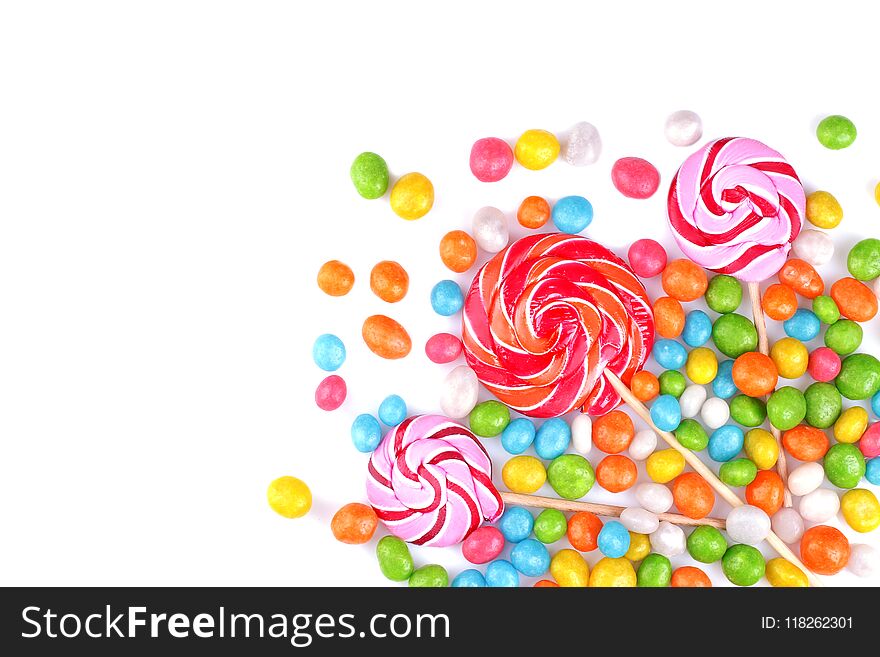 Multicolored lollipops and round candies on a white background. Top view. .