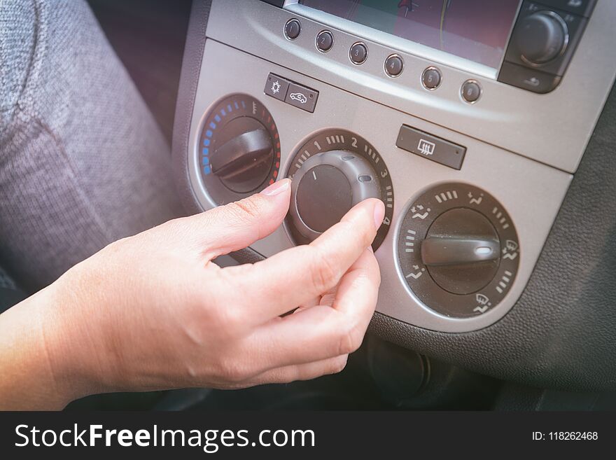 Driver adjusting car air-conditioning and ventilation system with fan speed selector knob. Driver adjusting car air-conditioning and ventilation system with fan speed selector knob