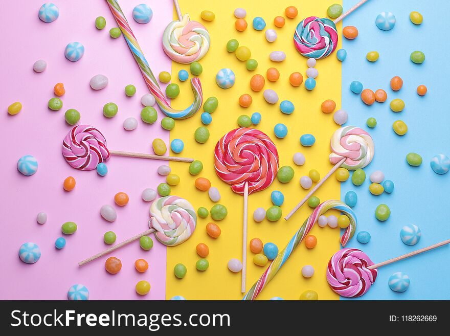 Multicolored round candy and colored lollipops on colored bright backgrounds.