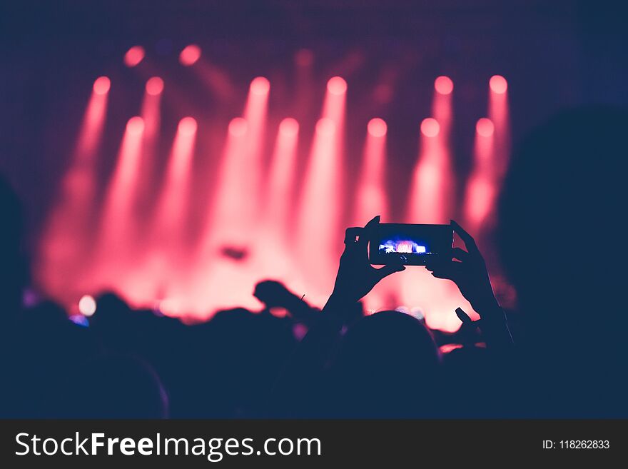 Hands Using Camera Phone To Take Pictures, Videos At Concert