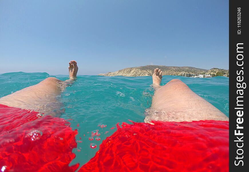 Legs Of A Swimmer In Red Swimwear Floating In The Sea