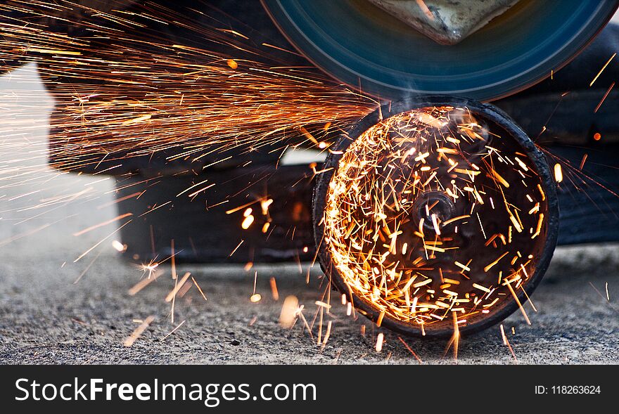 Cutting metal with grinder. Sparks while grinding iron