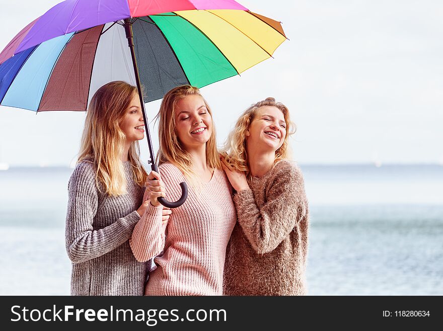 Three Women Under Colorful Umbrella