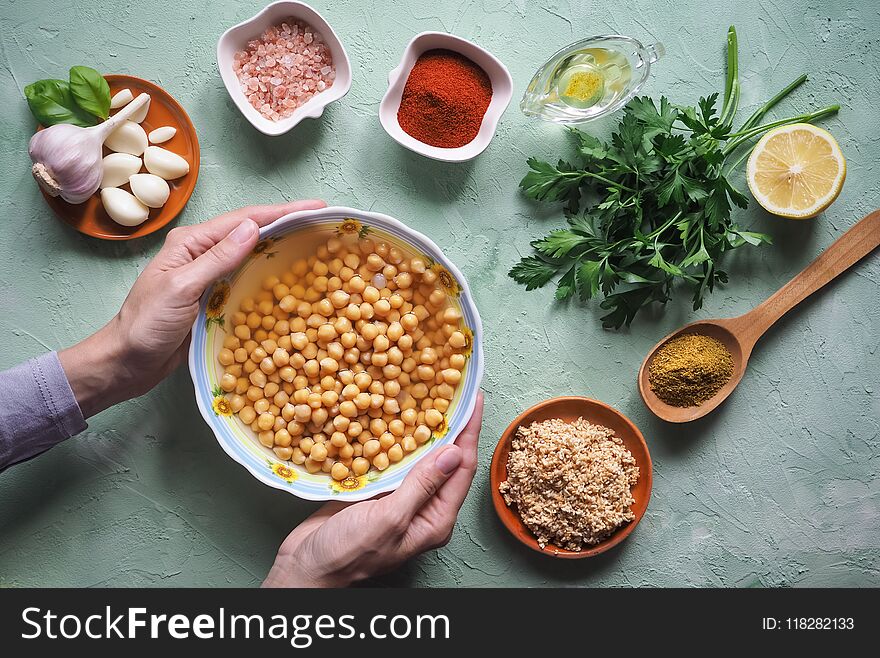 Chickpeas in hand. Ingredients for traditional hummus on the kitchen table.