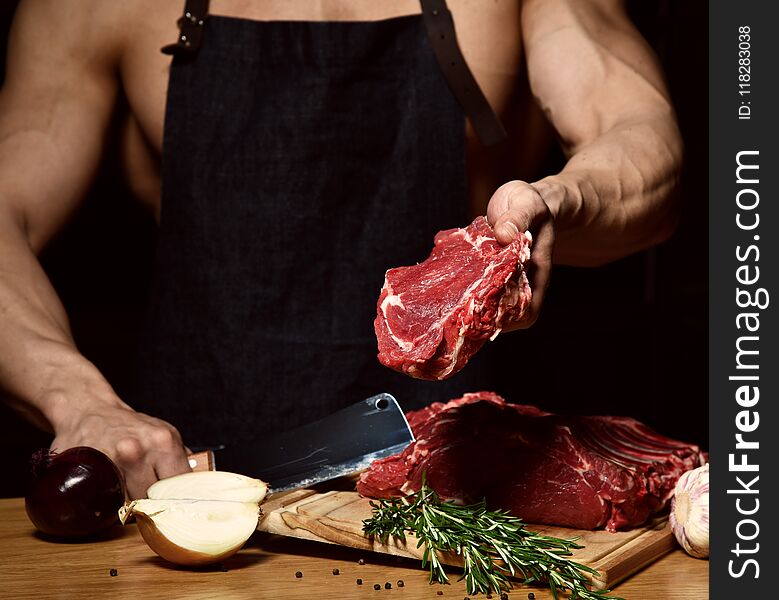 Strong sport man prepare cook beef steak ribs on dark kitchen background healthy eating concept on black
