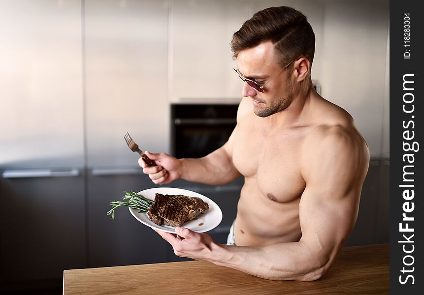 Man ready to eat cut with fork and knife grill beef steak on a kitchen