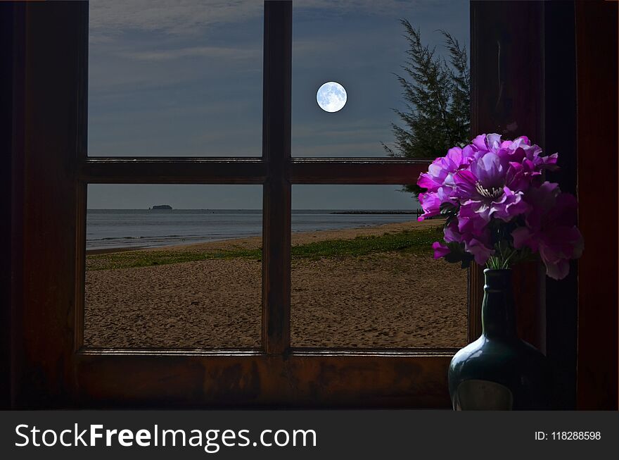 White full moon in the sky over the evening sea in resort window. White full moon in the sky over the evening sea in resort window