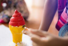 Close Up Hand Of Little Boy Painting Plaster Ice Cream Cone With Red And Yellow Stock Image