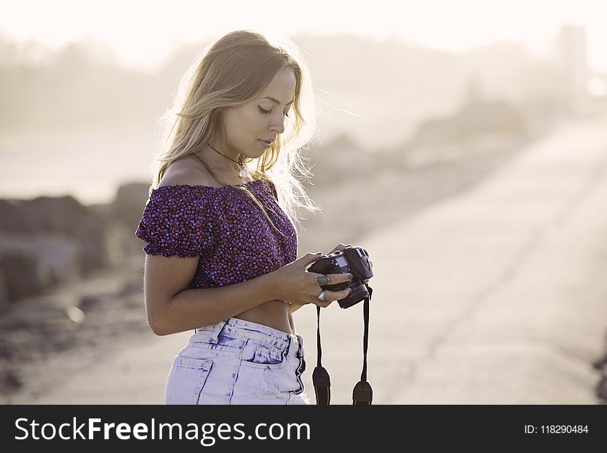 Woman in Purple Blouse Holding Camera