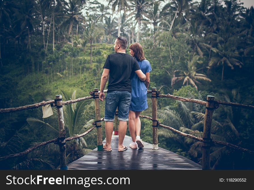 Man and Woman Standing on Hanging Bridge
