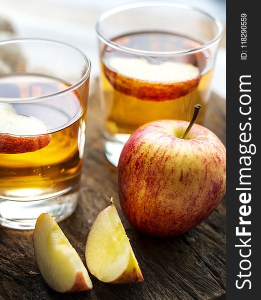 Sliced Apple Beside Two Apple Juice