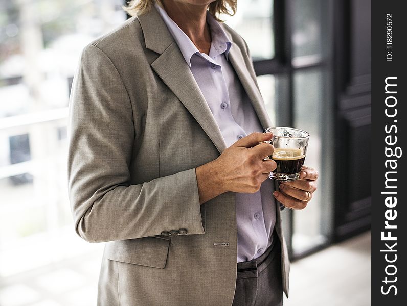 Person Wearing Suit Jacket Holding Glass Mug