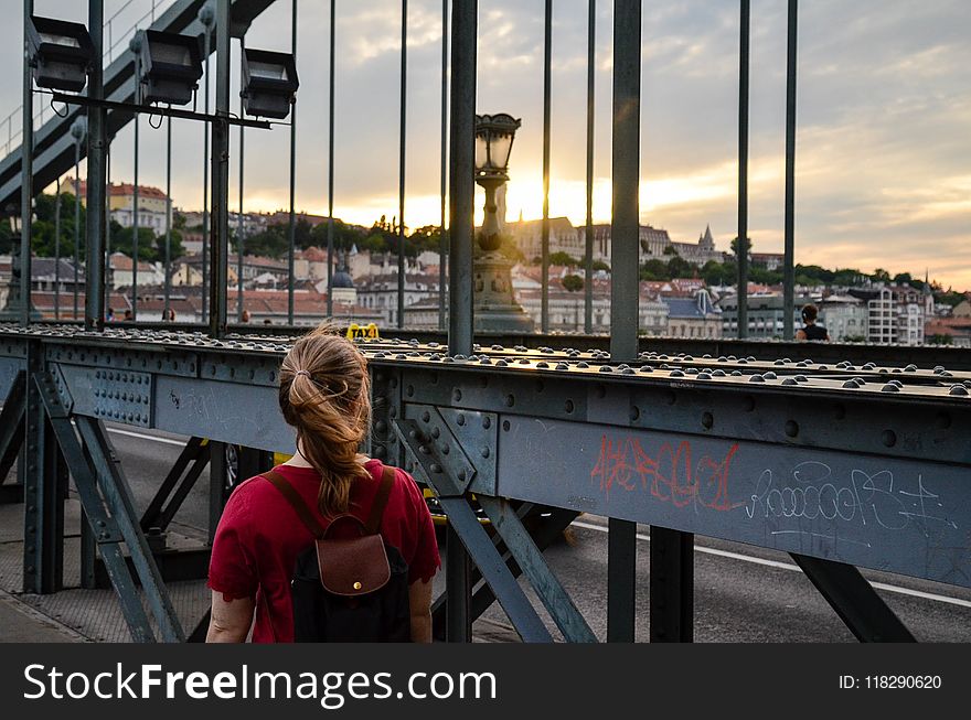 Woman Standing Facing a Bridge