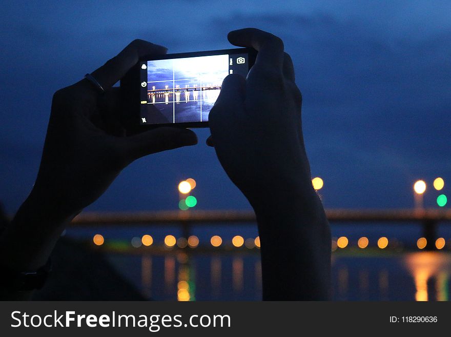 Person Taking A Photo A Of Bridge At Night