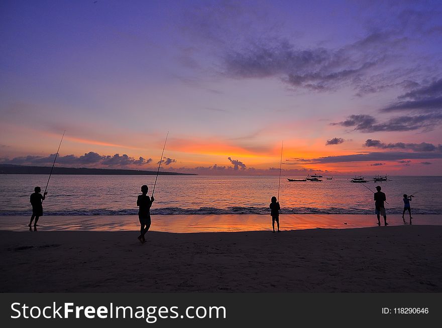 Silhouette Of Five People Standing On Seashore During Sunset