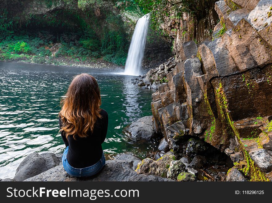 Girl watching the Bassin La Paix waterfall in Reunion Island