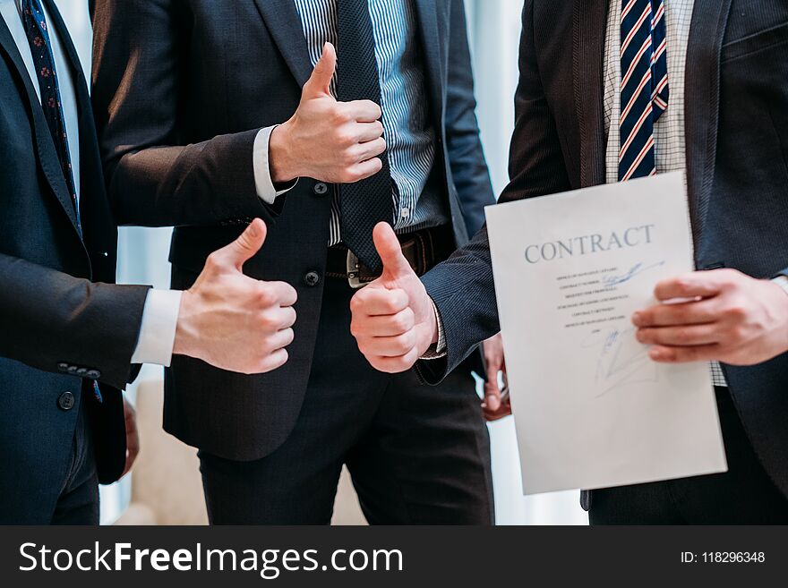 Success cooperation teamwork concept. deal sealing. contract signing. confident business men showing thumbs up. Success cooperation teamwork concept. deal sealing. contract signing. confident business men showing thumbs up.
