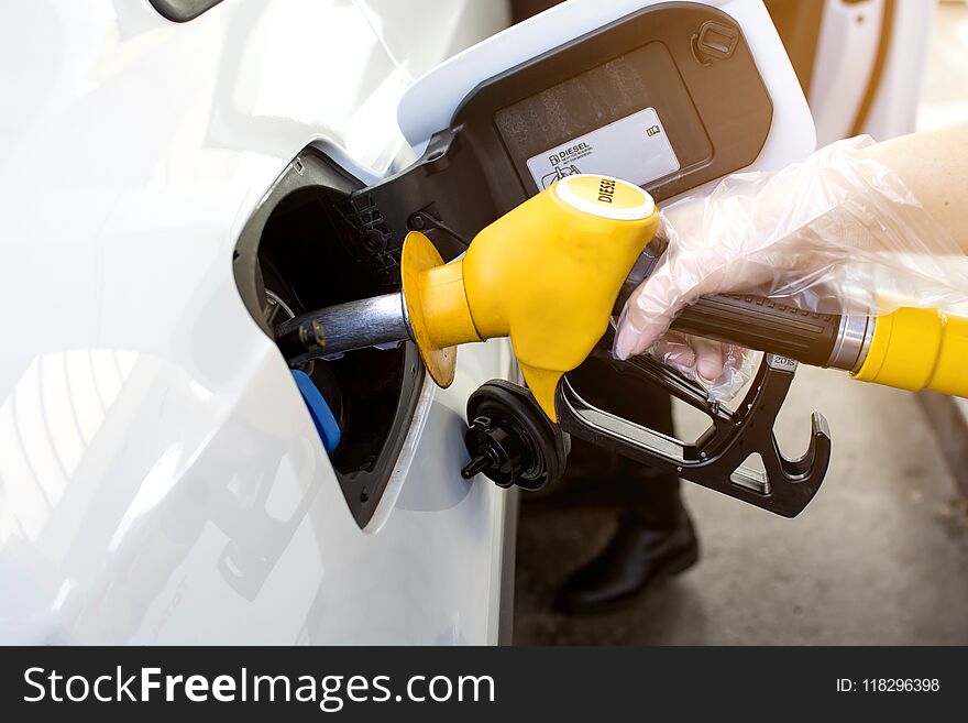 Woman hand refilling and pumping gasoline oil the car with fuel at he refuel station in Europe, industry or transportation concept