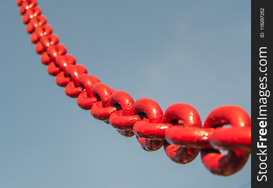 Red chain link into the sky. Selective focus.