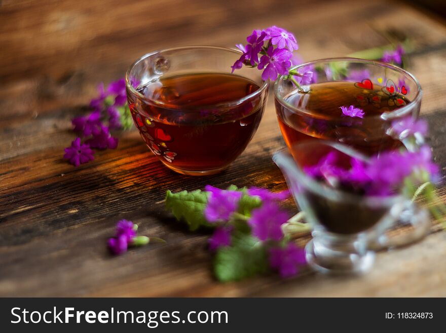 Lime Brewed Tea In A Cup On A Wooden Table. On A Table Scattered Linden Blossoms And Leaves