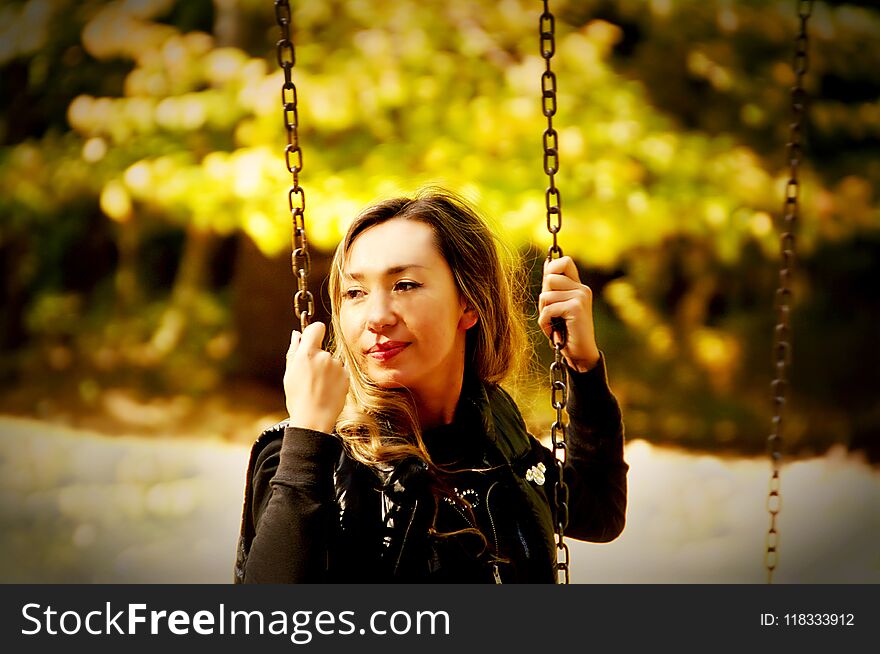 The Girl Of The Eastern Appearance Laughs And Swings On A Swing