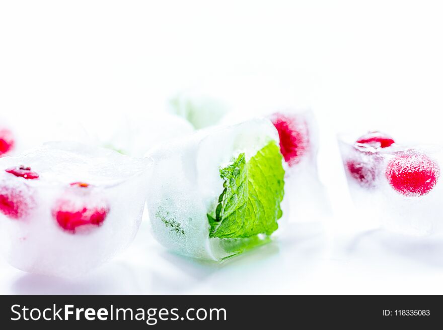 Ice Cubes With Red Berries And Mint White Background