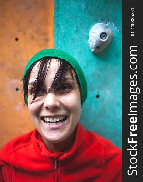 Portrait of a rock climber. A woman trains on a climbing wall. The face of a sportswoman.