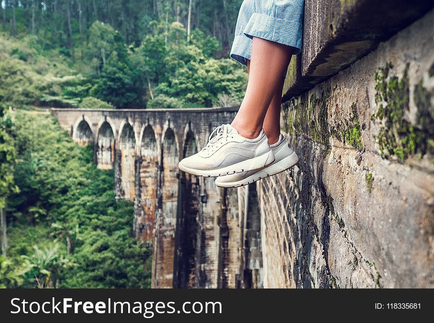 Woman sits on the Demodara nine arches bridge in Ella, Sri Lanka: close up feet image