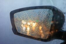 Rearview Mirror With Drops Of Water From The Rain And A Car With Headlights. Selective Focus, Shallow DOF Stock Photos